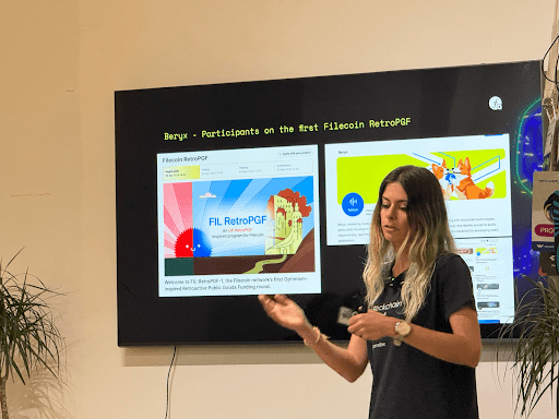 A person stands in front of a screen displaying a presentation about Filecoin RetroPGF